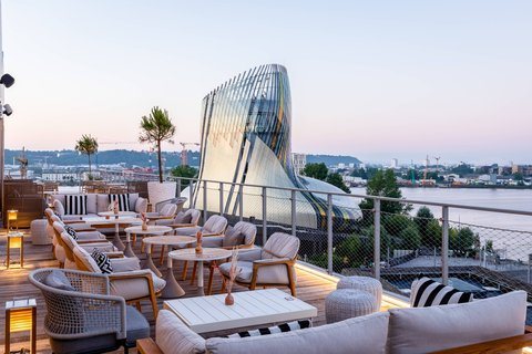 Fauteuils du rooftop Gina au coucher du soleil, hôtel Renaissance Bordeaux