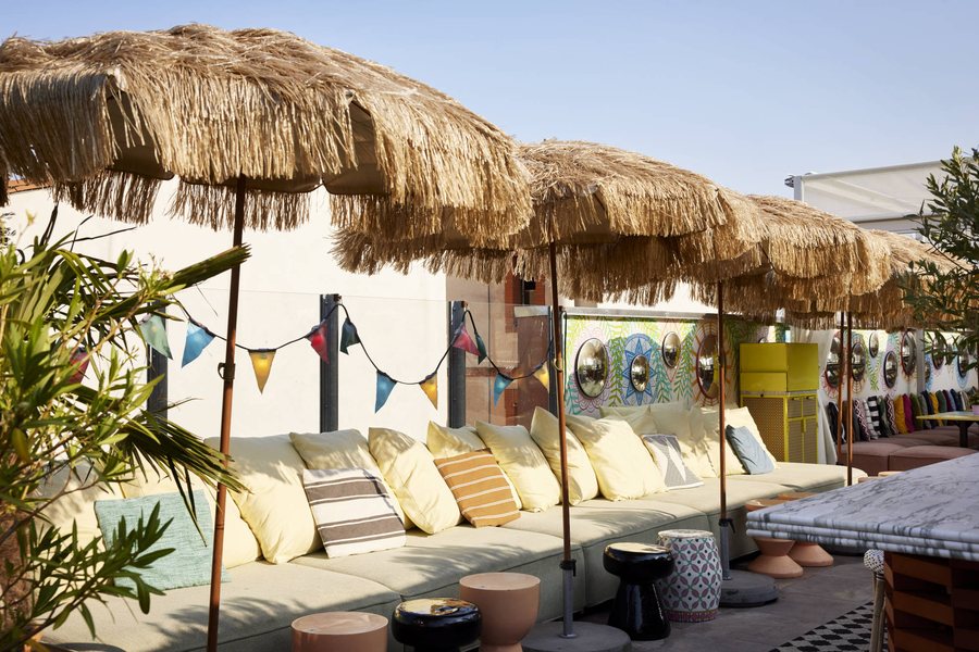 Banquettes et parasols en paille du rooftop du Mama Shelter Toulouse
