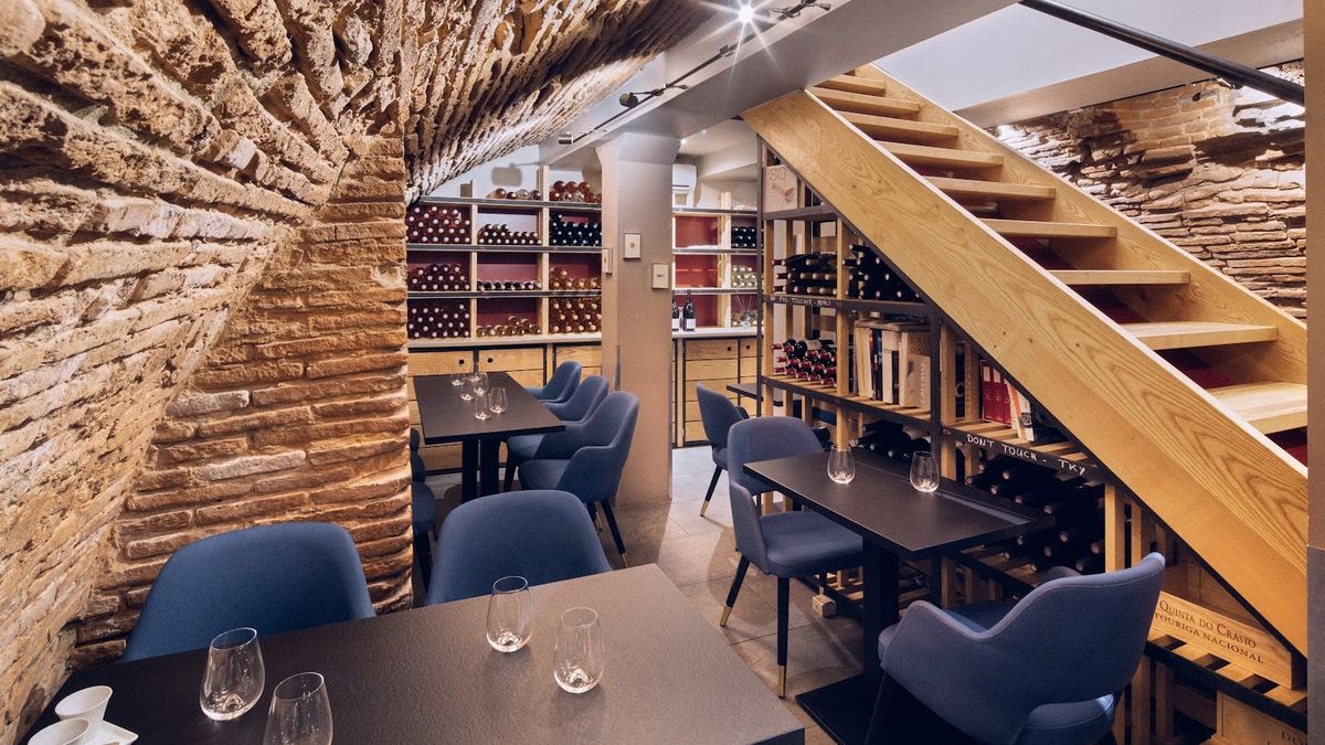 Cave voûtée en briques du N°5 Wine Bar à Toulouse, tables et escalier