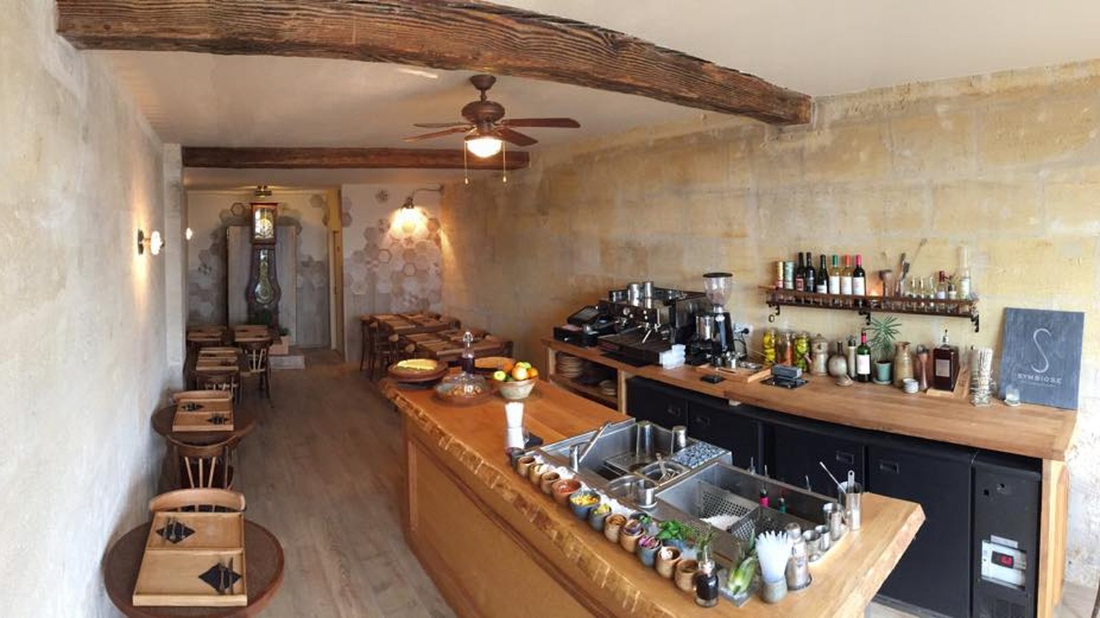 Comptoir en bois et murs de pierre du bar caché de Symbiose, quai des Chartrons à Bordeaux